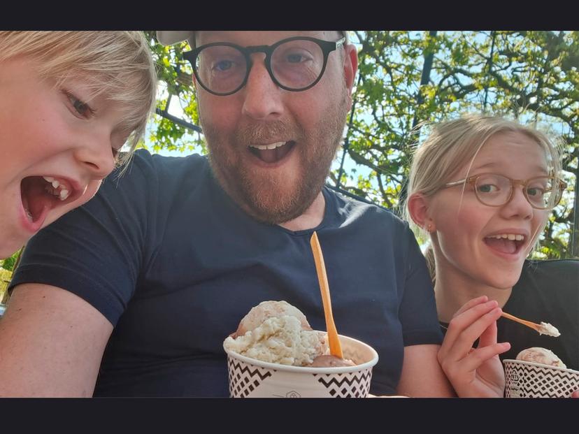 Elsa en Isis eten een ijsje met hun vader.