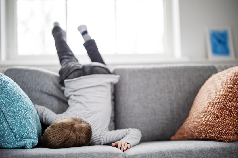 Cute child lying face down on the sofa